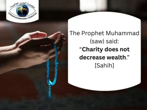 Hands holding praying beads in a mosque prayeing to god with a text next to it "The Prophet Muhammad (saw) said: “Charity does not decrease wealth.” [Sahih]"